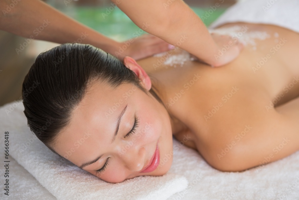 Brunette enjoying a massage lying on towel Brunette enjoying a massage lying on towel