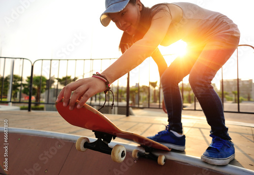 woman skateboarder legs skateboarding at skatepark
