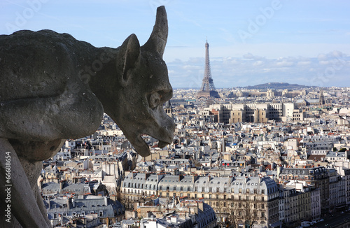 Gargoyle on Notre-dame cathedral in Paris with Eiffel t