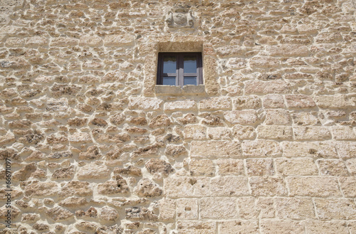Piccola finestra su muro di pietra leccese