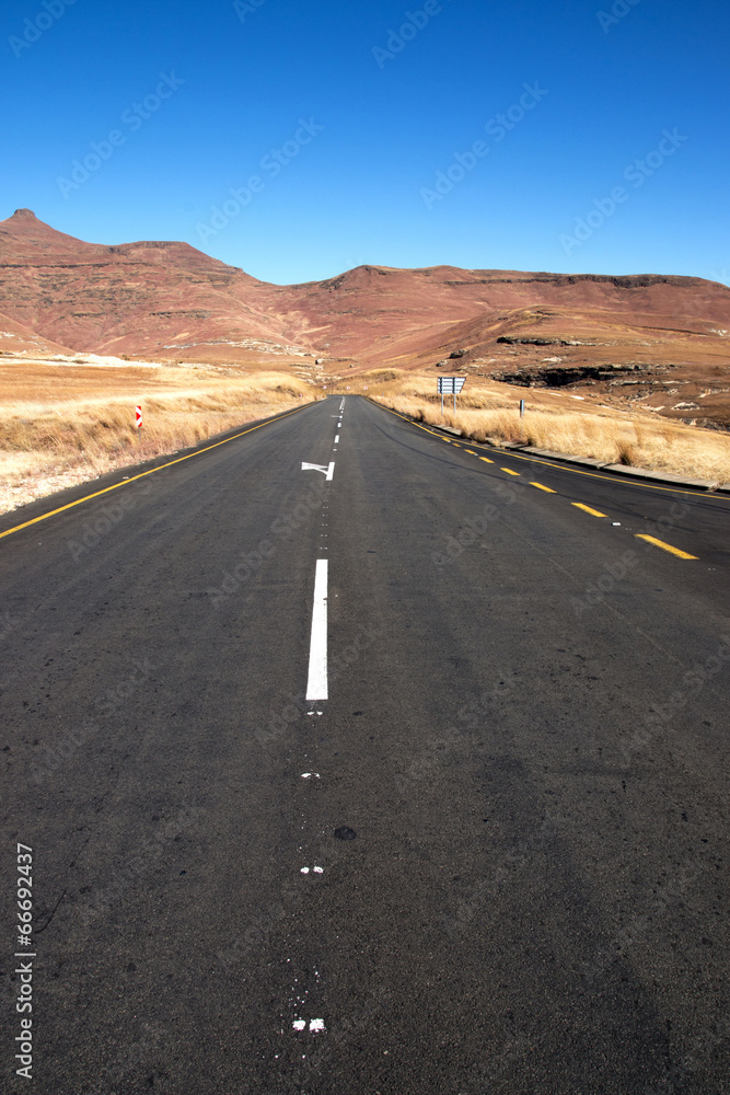 Straight Asphalt Road Heading Towards Hilly Terrain Straight Asphalt Road Heading Towards Hilly Terrain