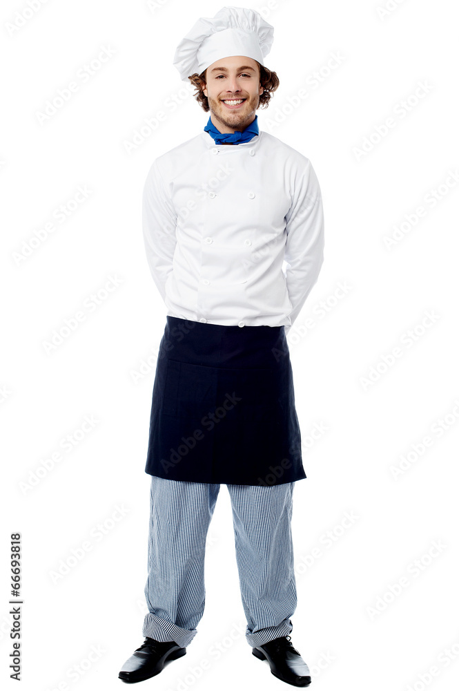 Young chef standing with hands behind Young chef standing with hands behind
