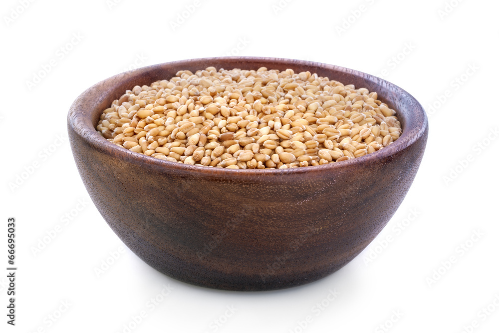 Ripe wheat in a wooden bowl isolated on white background Ripe wheat in a wooden bowl isolated on white background
