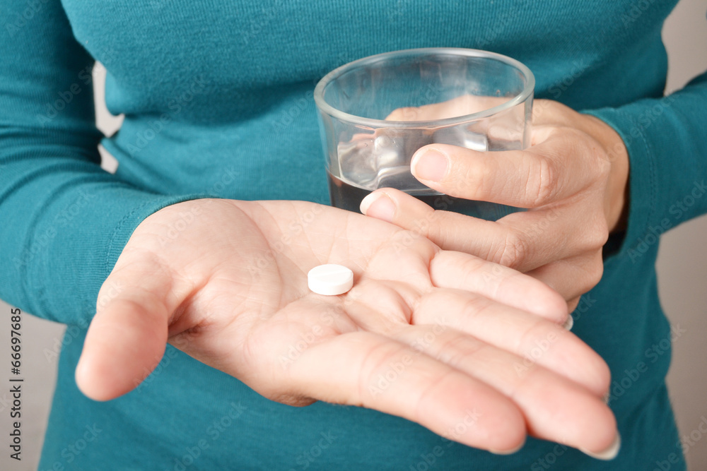 person taking a pill with a glass of water person taking a pill with a glass of water