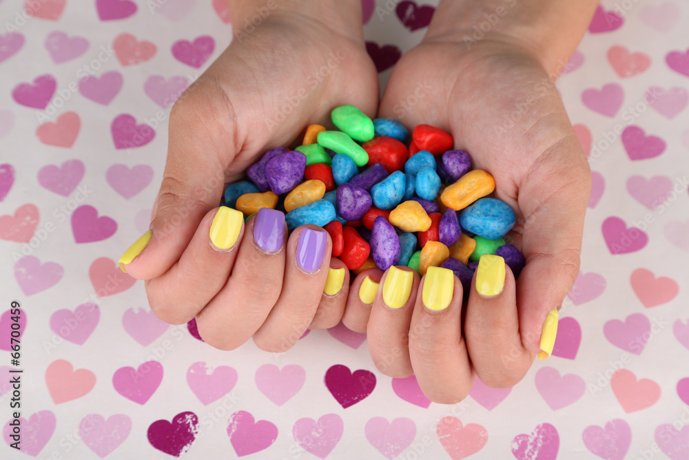 Female hand with stylish colorful nails holding colorful