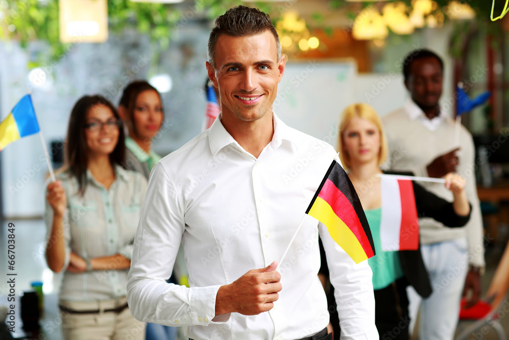Fototapeta premium Smiling businessman holding flag of Germany