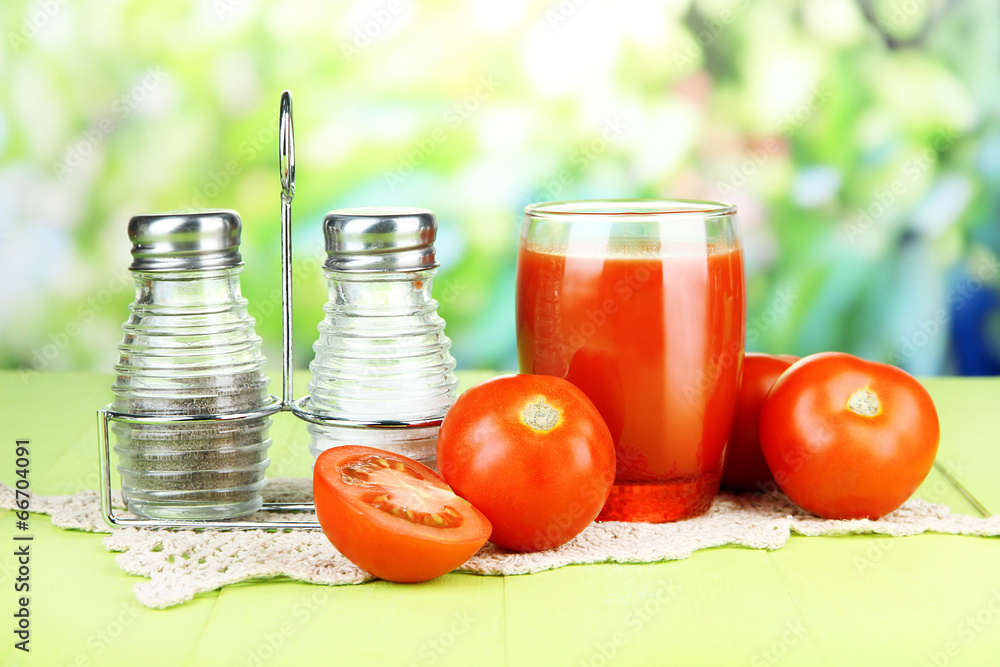 Tomato juice in glass, on wooden table, on bright background Tomato juice in glass, on wooden table, on bright background
