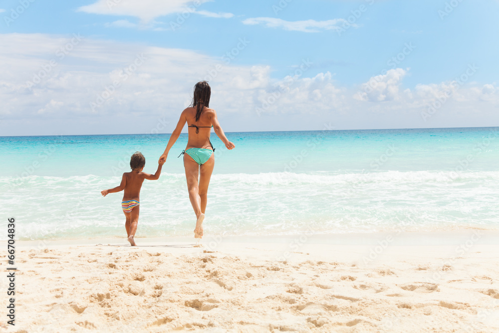 Child and woman running to the sea holding hands Child and woman running to the sea holding hands