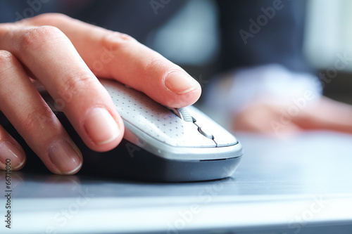 female hand clicking computer mouse photo