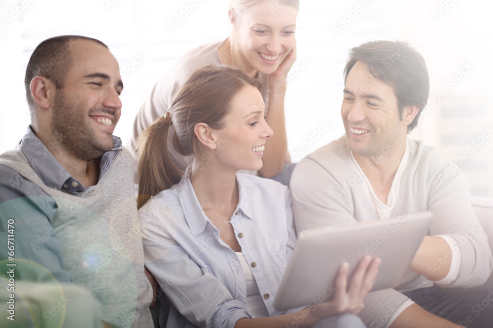Group of friends at home using tablet in couch Group of friends at home using tablet in couch