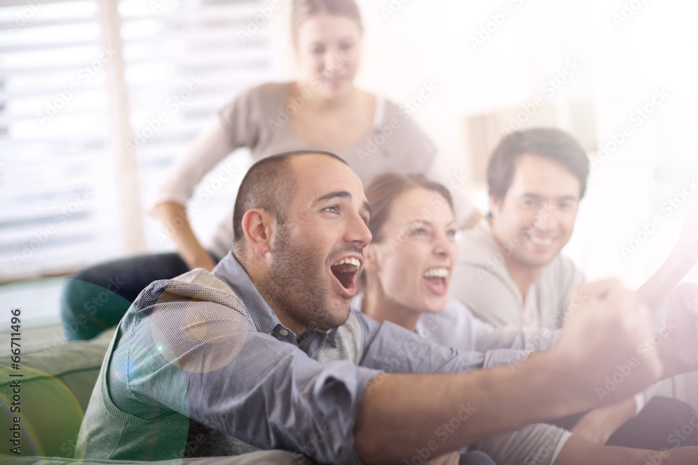 Fototapeta premium Cheerful group of friends watching football game on tv
