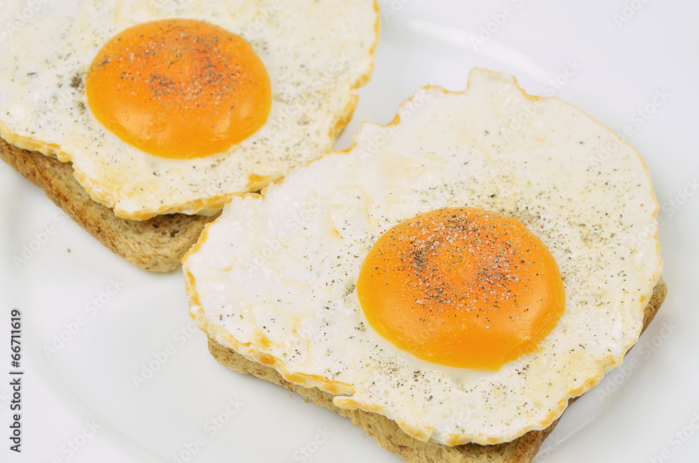 Spiegeleier mit Salz und Pfeffer auf Toast Spiegeleier mit Salz und Pfeffer auf Toast