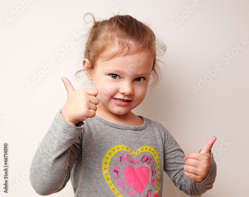 Happy kid girl showing thumbs up sign