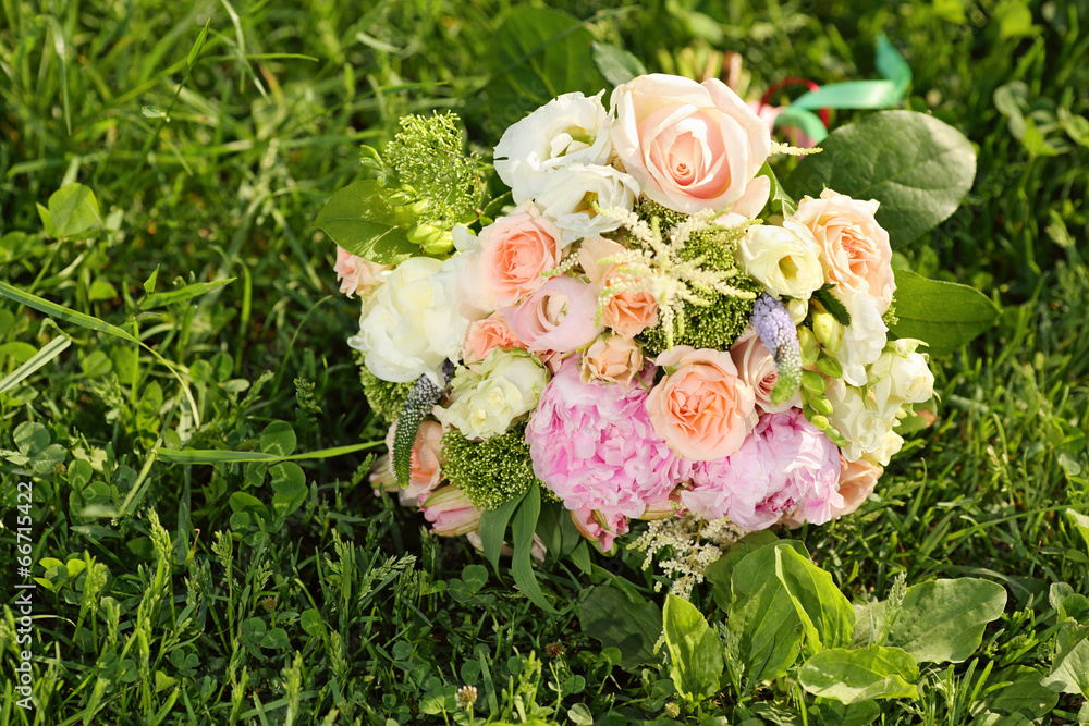 Beautiful bouquet of roses is on green grass at sunny summer day Beautiful bouquet of roses is on green grass at sunny summer day