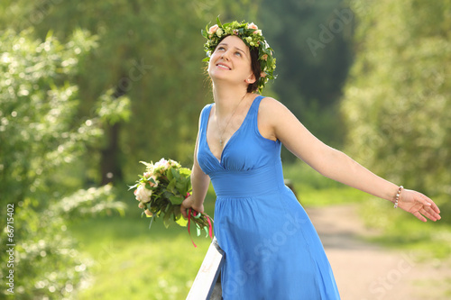 Beautiful smiling woman in blue dress with bouquet depicts bird photo