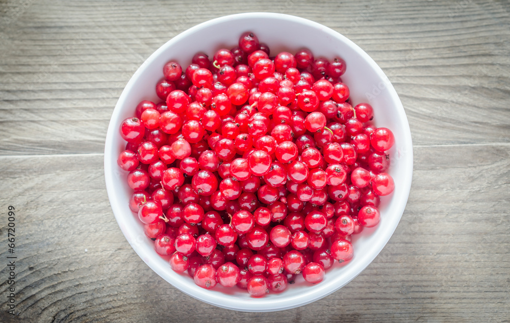 Bowl with fresh redcurrant on the wooden table Bowl with fresh redcurrant on the wooden table