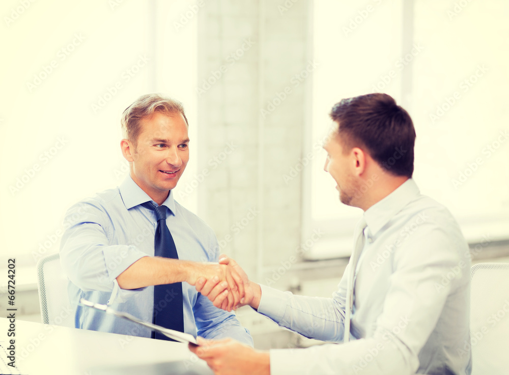 businessmen shaking hands in office