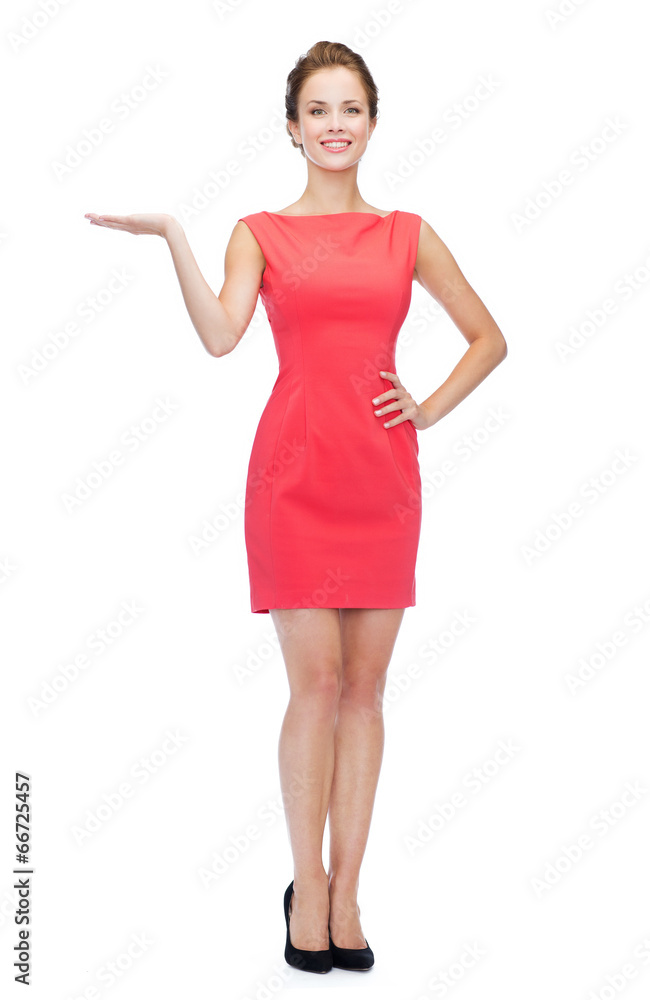 smiling young woman in dress holding something smiling young woman in dress holding something