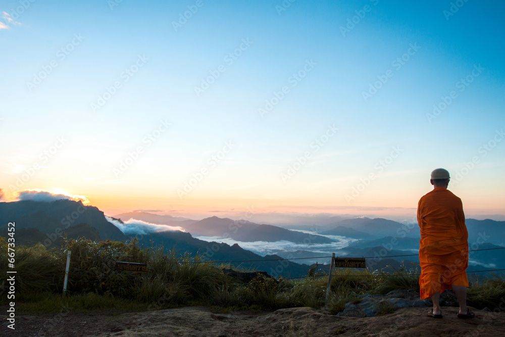 Monk views sunrise scene at Phu chi fa in Chiangrai,Thailand