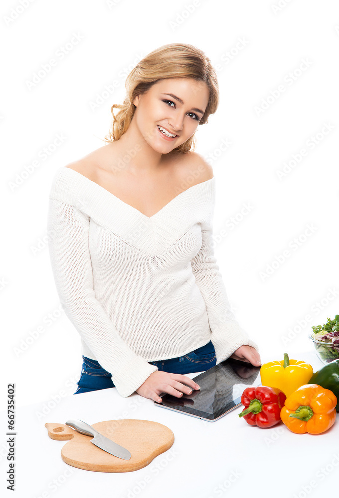 Young and beautiful housewife woman cooking in a kitchen Young and beautiful housewife woman cooking in a kitchen