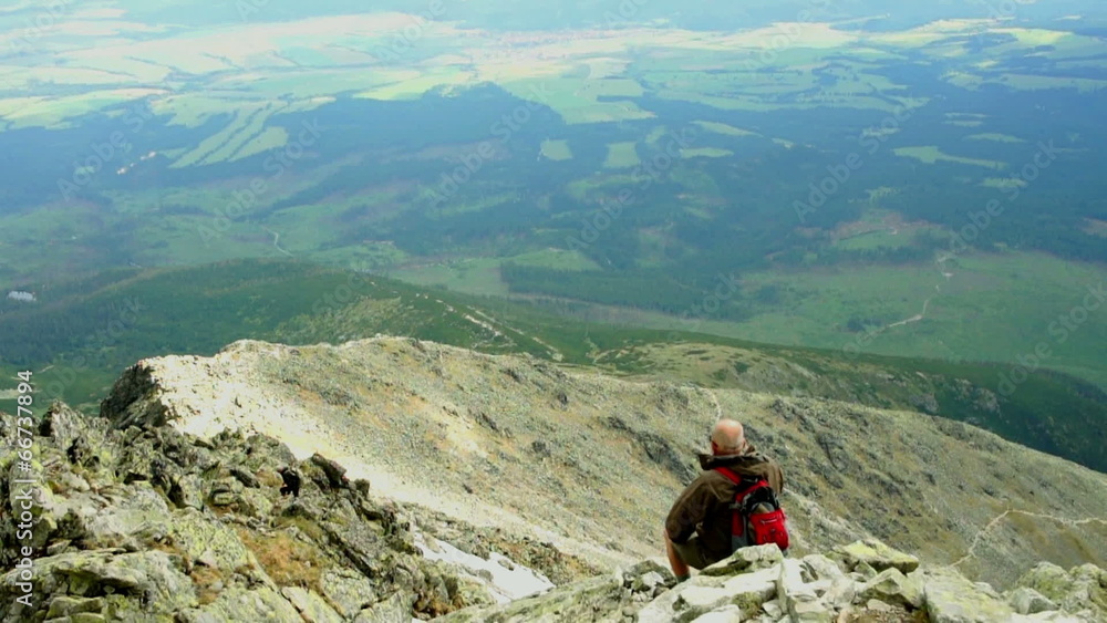 Man at the mountain peak looking at beautiful view Man at the mountain peak looking at beautiful view
