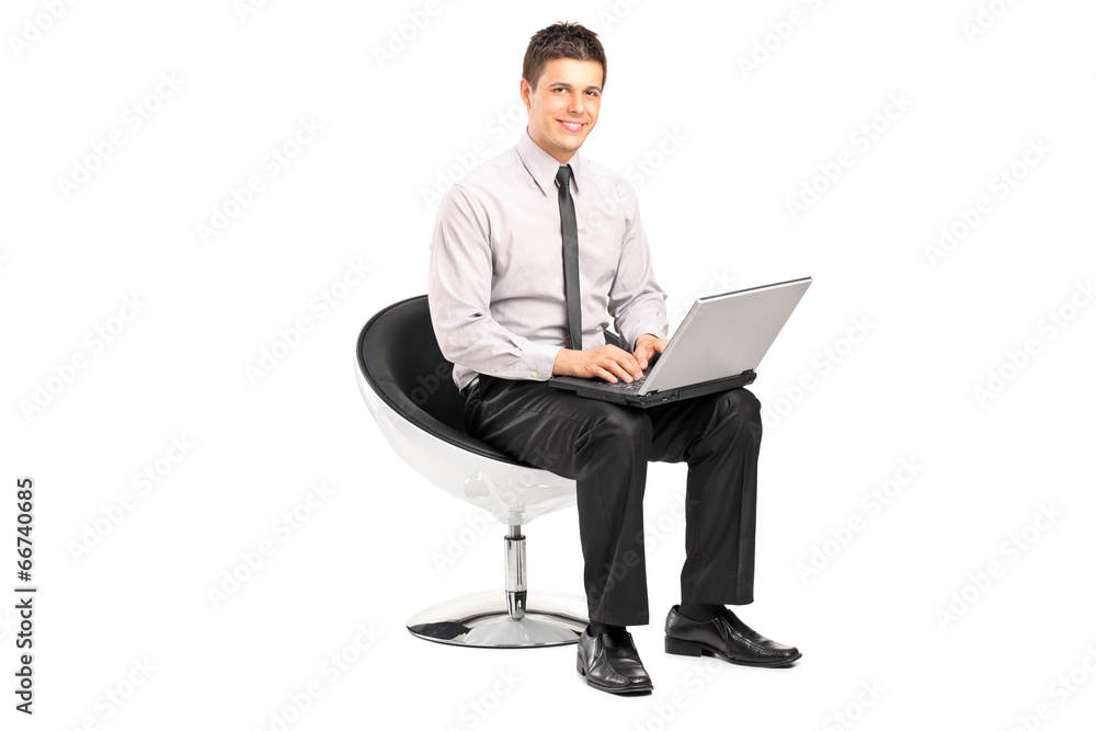 Man working on laptop seated in a modern chair Man working on laptop seated in a modern chair