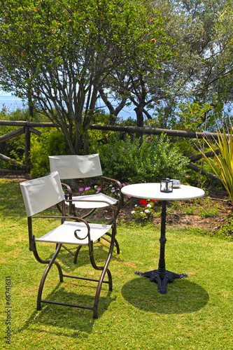 Table and iron chairs in garden with sea view(Greece)