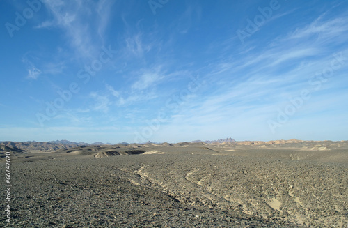  desert covered by black stones