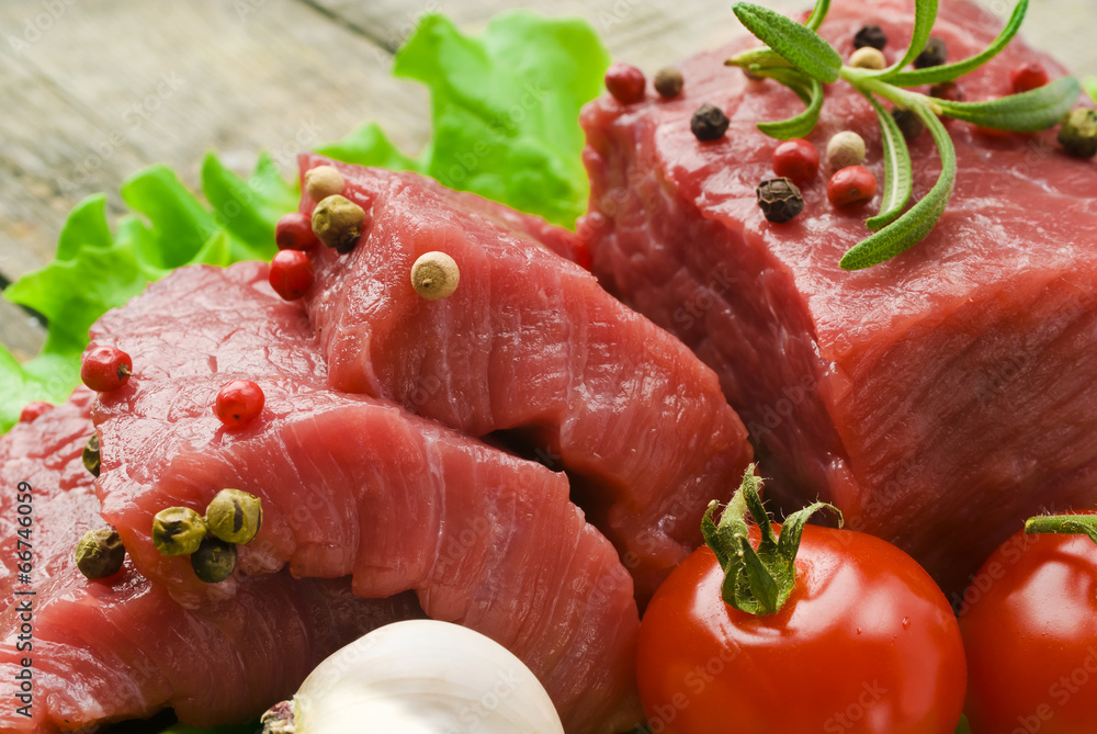 Raw Steak with green lettuce on wooden board Raw Steak with green lettuce on wooden board