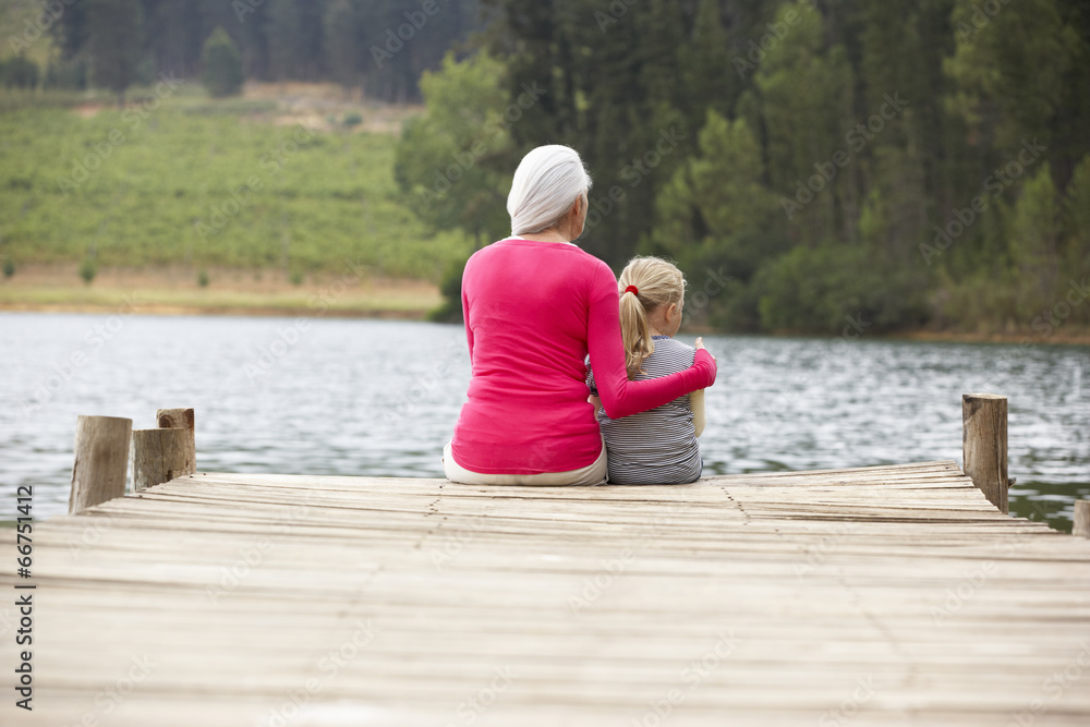 Grandmother and granddaughter sitting on a jetty Grandmother and granddaughter sitting on a jetty