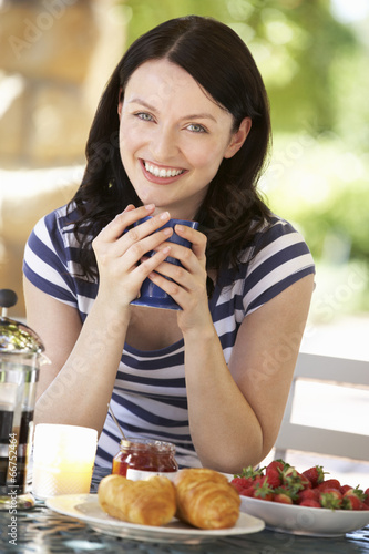 Woman eating breakfast outdoors