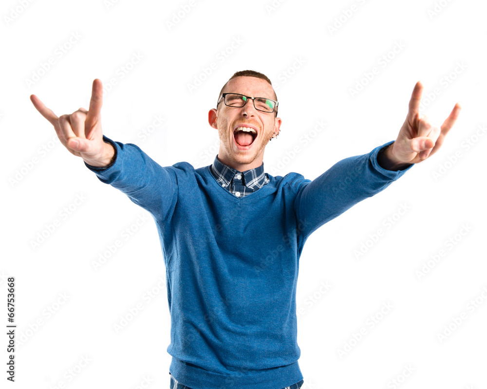 Young man doing the horn gesture over white background Young man doing the horn gesture over white background
