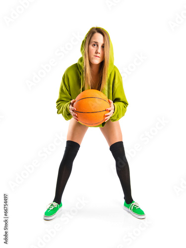 Pretty young girl wearing urban style with basketball
