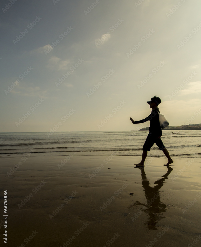 Anciana paseando por la playa