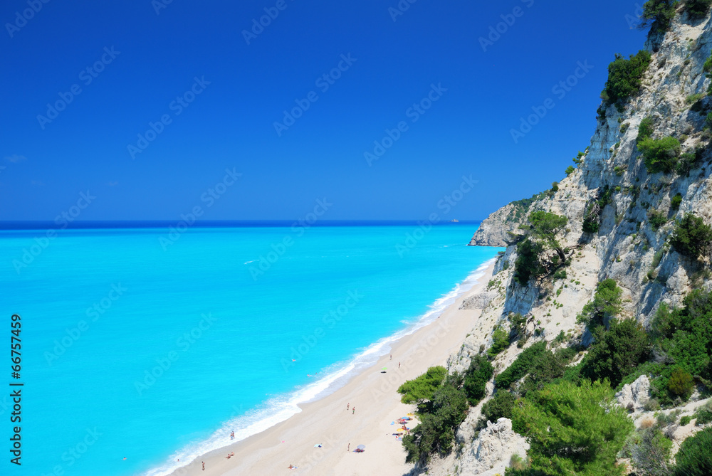 Steep cliffs and large beach with turquoise sea Steep cliffs and large beach with turquoise sea