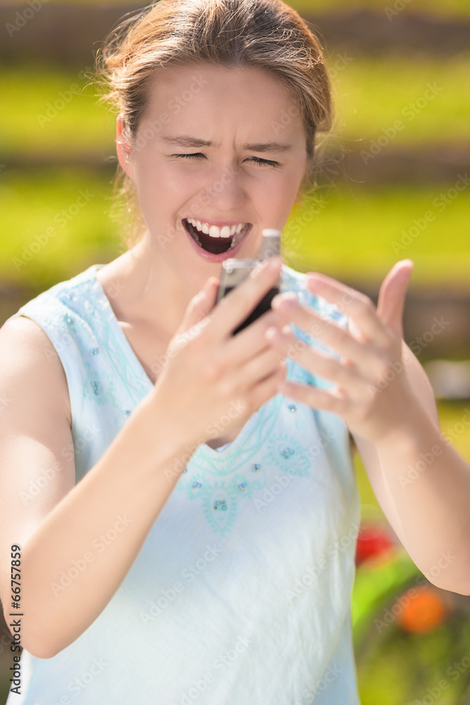 Angry and Furious Young Caucasian Woman With Cellphone on Hands Angry and Furious Young Caucasian Woman With Cellphone on Hands