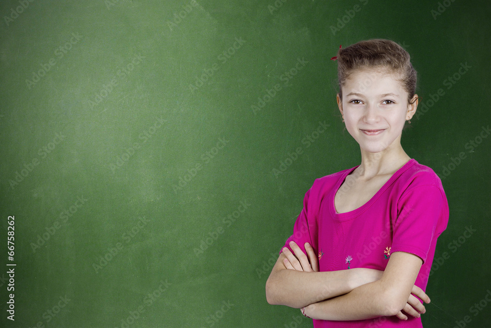 Confident happy, young student standing by chalkboard