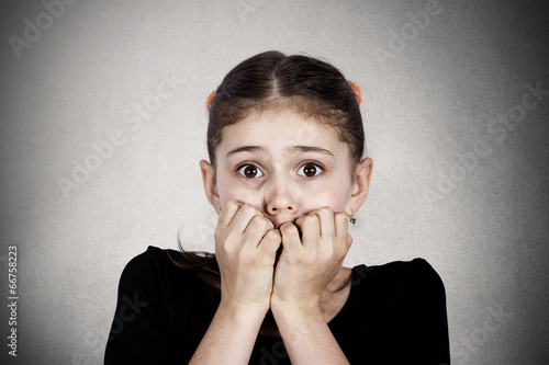 Foto headshot scared, stressed little girl on grey wall background