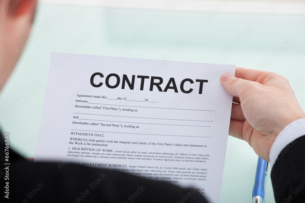 Businessman Reading Contract Paper At Desk Businessman Reading Contract Paper At Desk