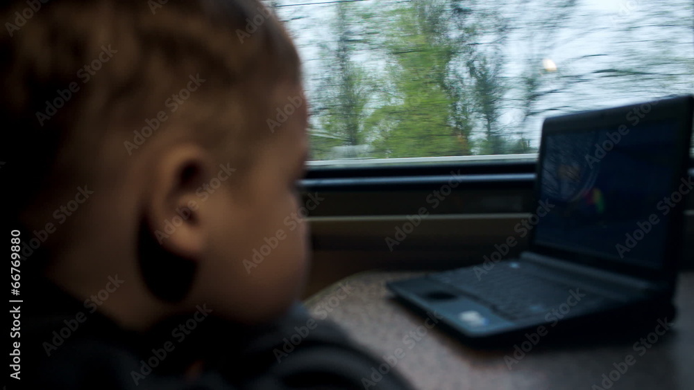 Boy watching movie or cartoon on laptop in the train Boy watching movie or cartoon on laptop in the train