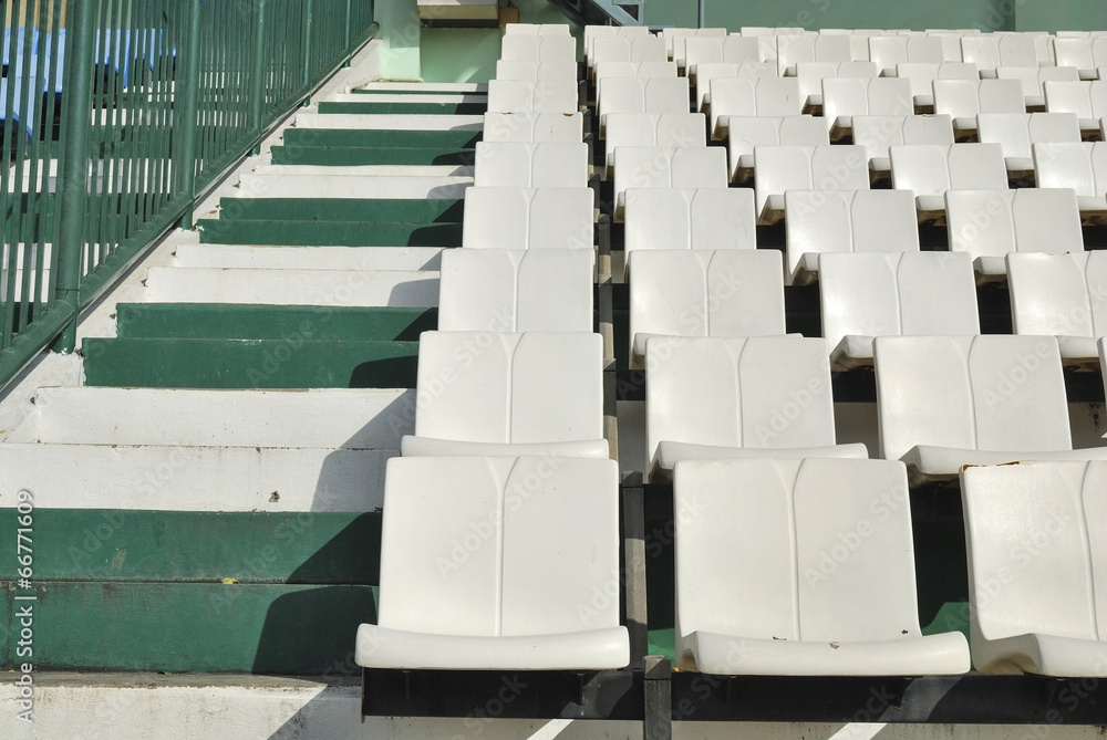 Fototapeta premium Rows of broken and stained white chairs in an outdoor auditorium