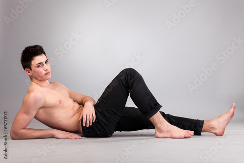 Healthy muscular young man on grey background