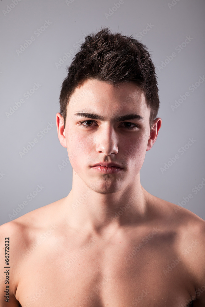 Handsome face of a young man on grey Handsome face of a young man on grey