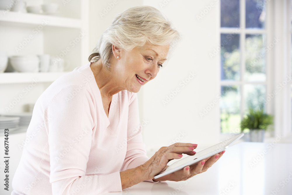 © Monkey Business - Senior woman using tablet at home