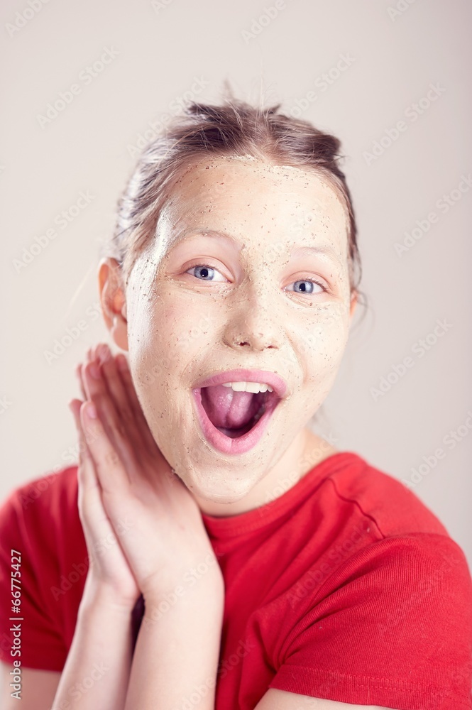 Happy teen girl with scrub mask on her face Happy teen girl with scrub mask on her face