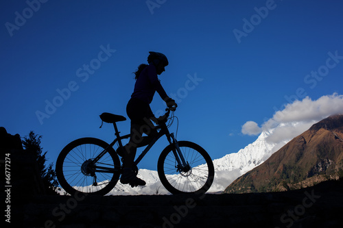 Girl cycling at the road in Himalaya