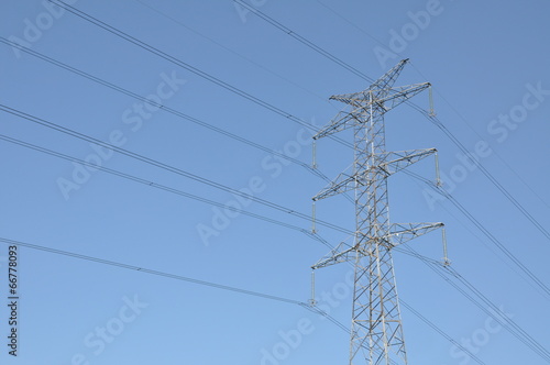 Power transmission tower against blue sky