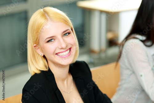 Young happy businesswoman sitting at office