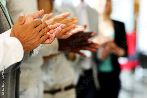Close-up of business people clapping hands.