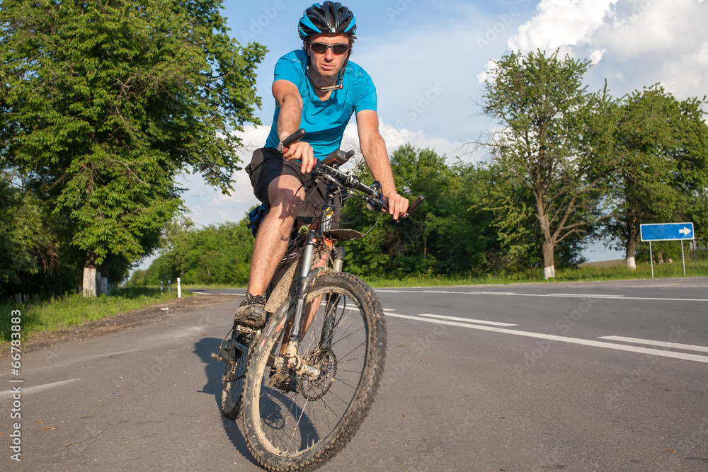 Fototapeta premium Man cycling at the road